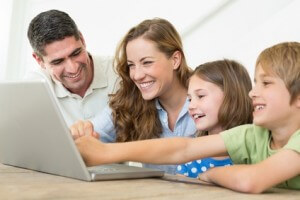 Smiling family using laptop